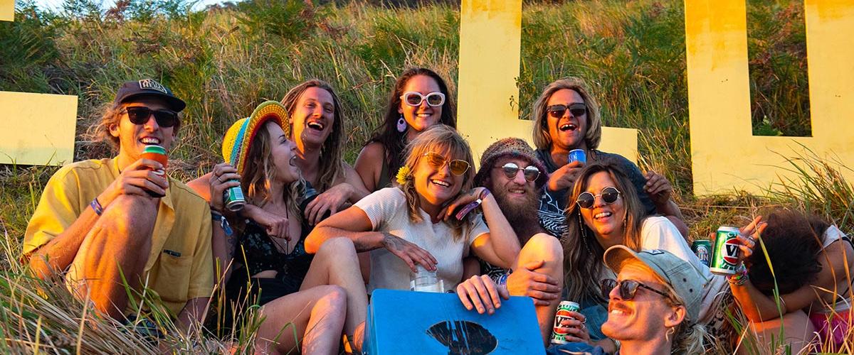 A group of friends sitting in front of a Jungle Love sign